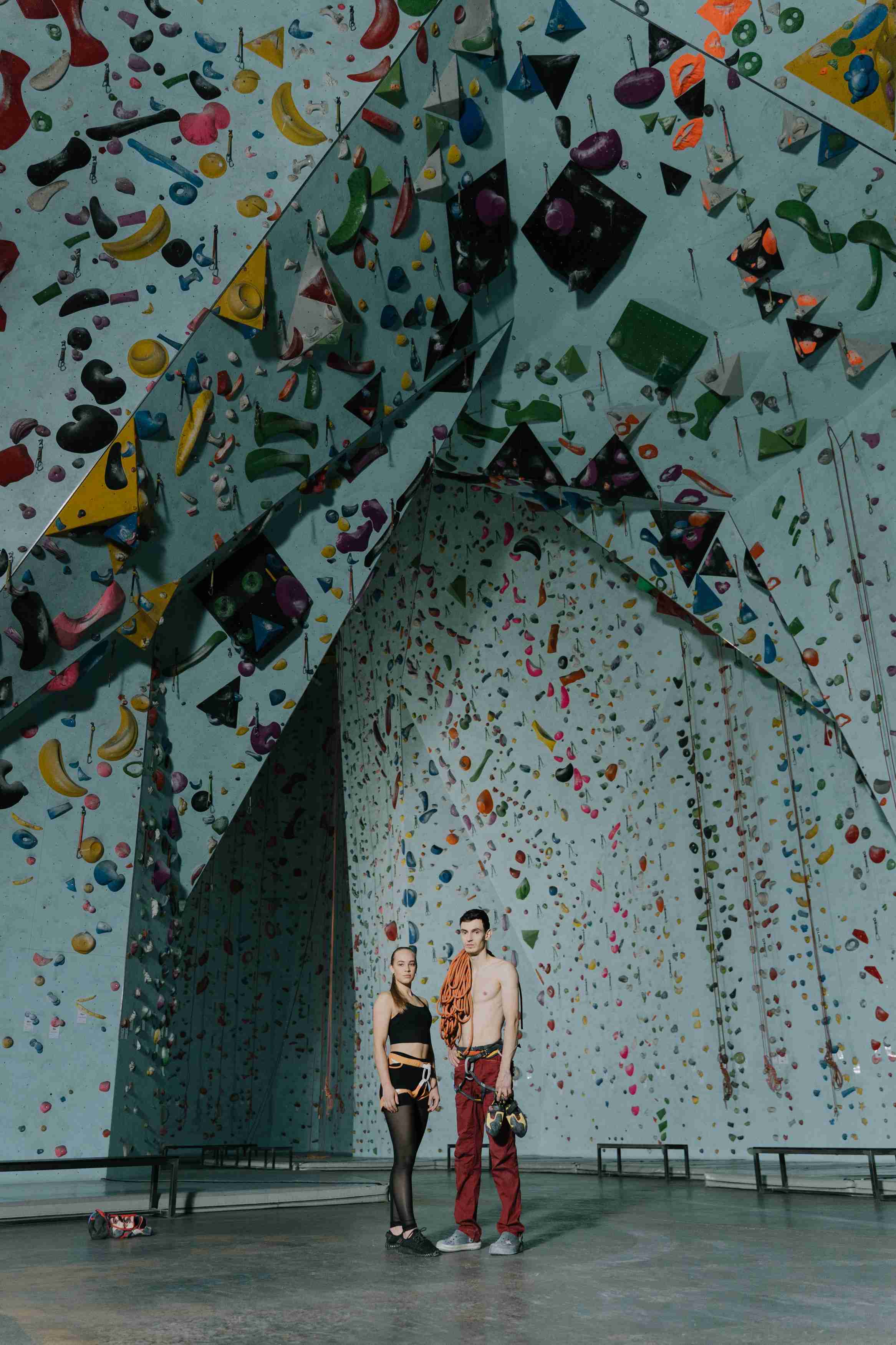 Two climbers standing in front of a climbing wall