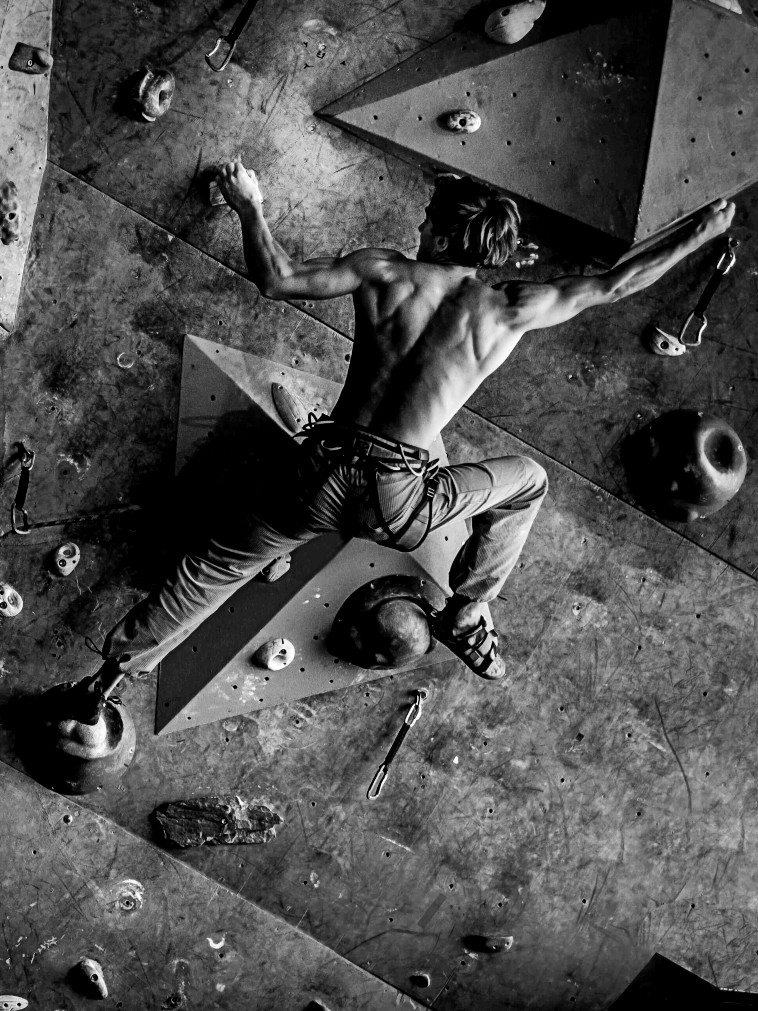 Black and white image showing a man bouldering (smaller)