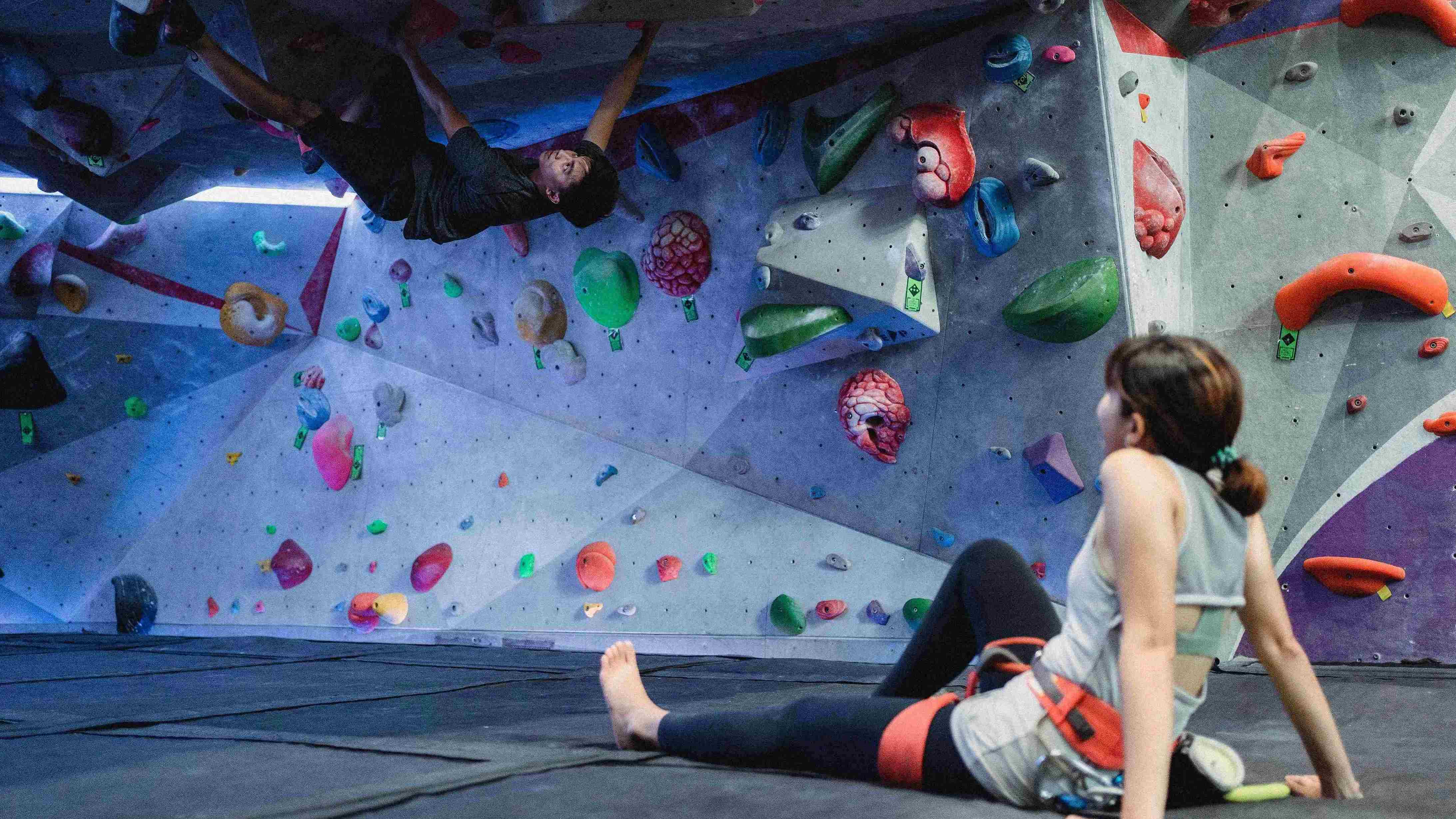 Anonymous barefoot climber and ethic partner ascending artificial rock