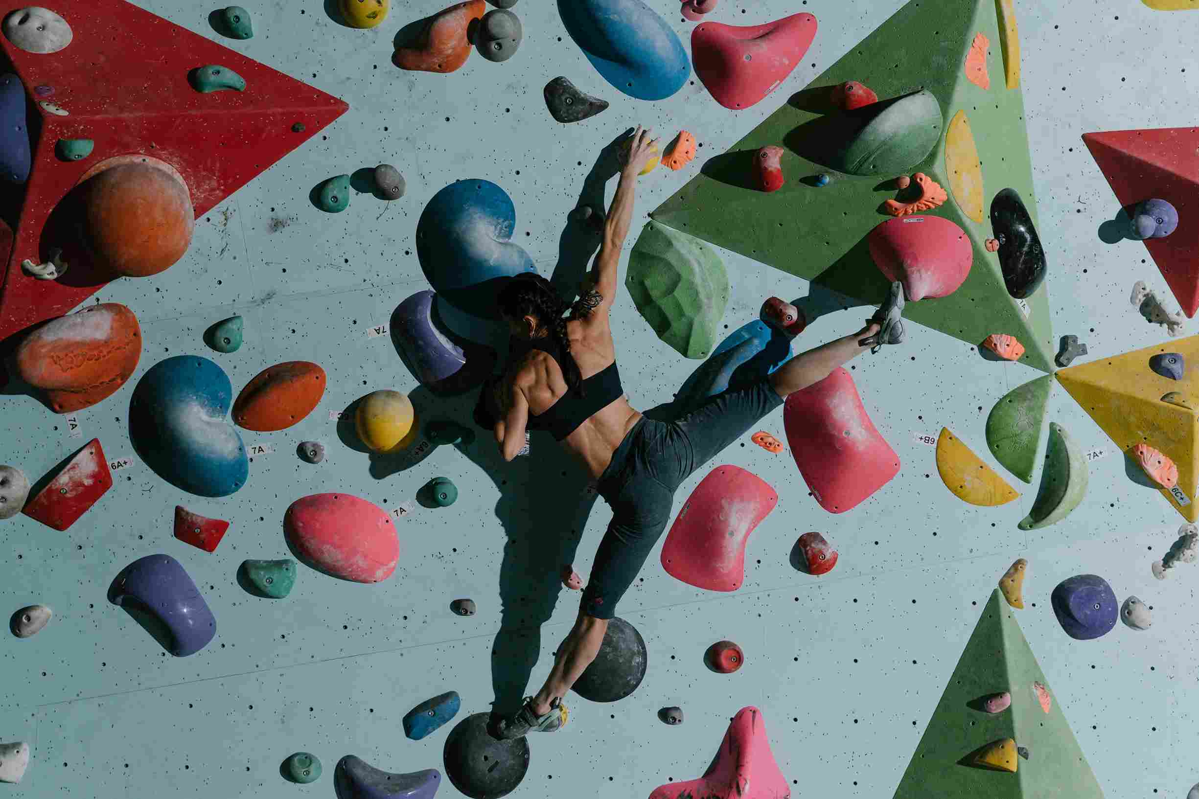 A Woman Climbing a Bouldering Wall